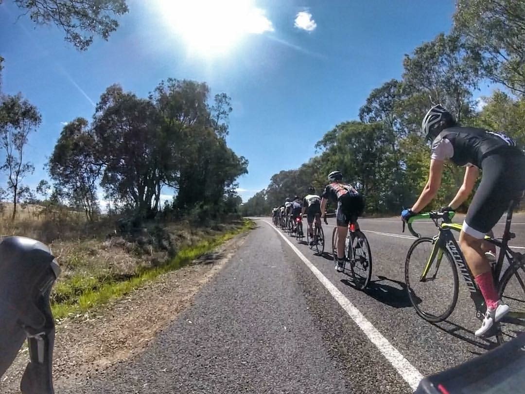 Cyclists riding in a group on an open road during a training or race scenario
