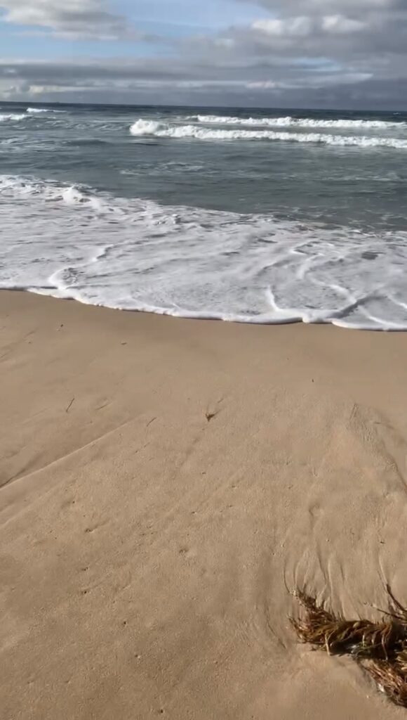 Gentle waves washing onto a quiet sandy beach.