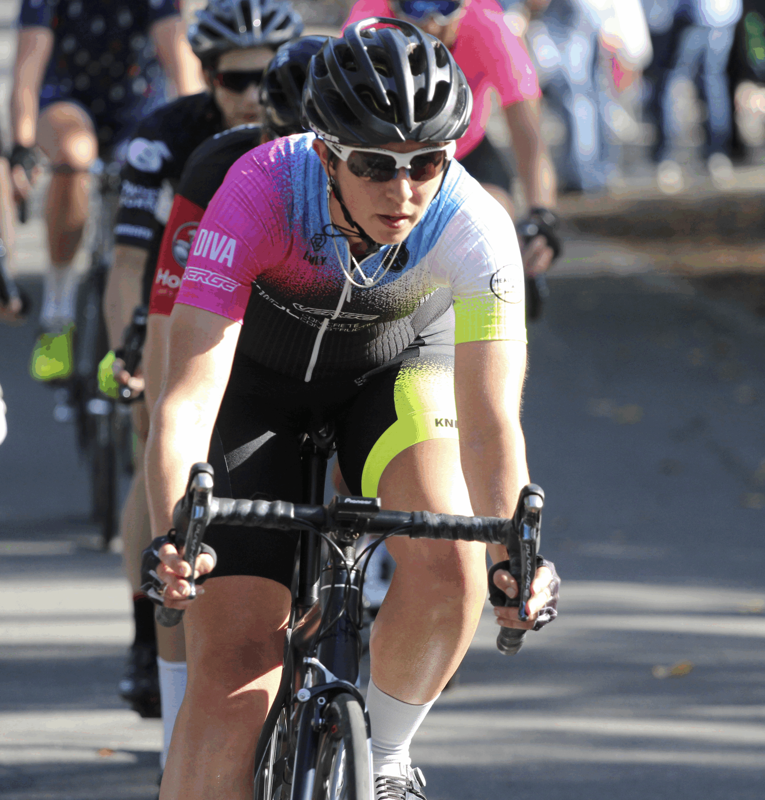 A cyclist in a road race concentrating while riding in a group, demonstrating focus and performance under pressure.