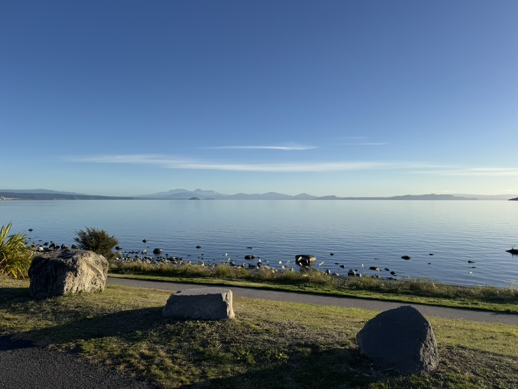 Wide view across calm water toward a distant horizon under an open sky, representing long-term direction and sustained effort beyond visible outco